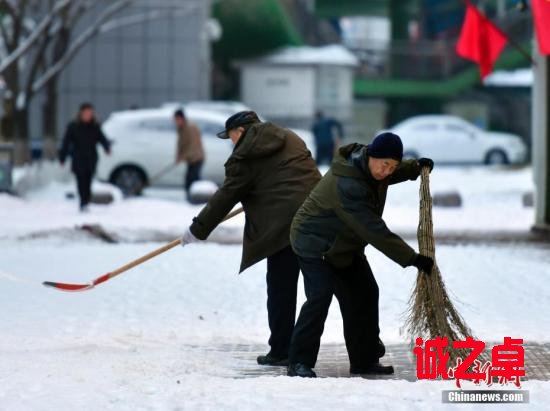 農(nóng)歷狗年正月初一，民眾在烏魯木齊街頭清理人行道上的積雪。中新社記者 劉新 攝