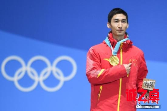 圖為武大靖在獲頒金牌后手指胸前五星紅旗。中新社記者 崔楠 攝