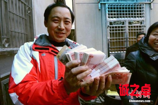 圖為工人領(lǐng)到工資。中新網(wǎng) 嚴(yán)公軒 攝